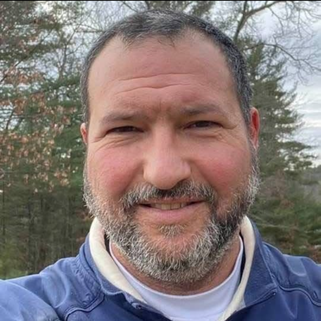 White male with grey beard and hair.